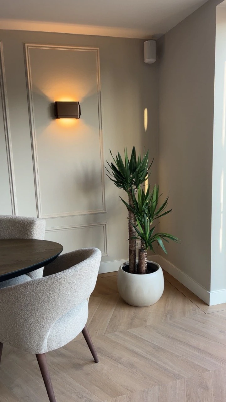 Interieur met greige wandpanelen, wandlamp en hoge kamerplant