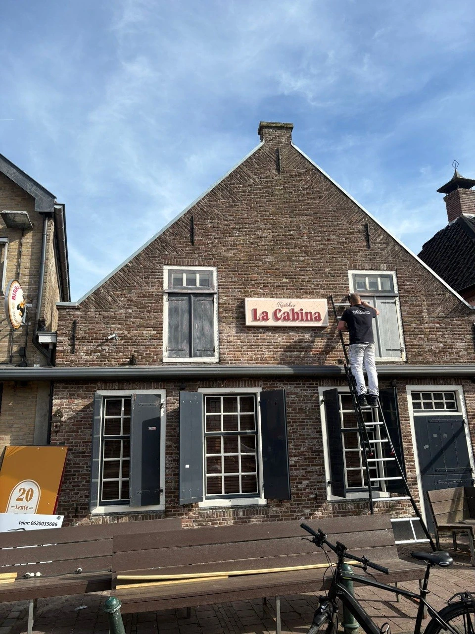 Voor buitenschilderwerk: gevel van La Cabina met schilder op ladder